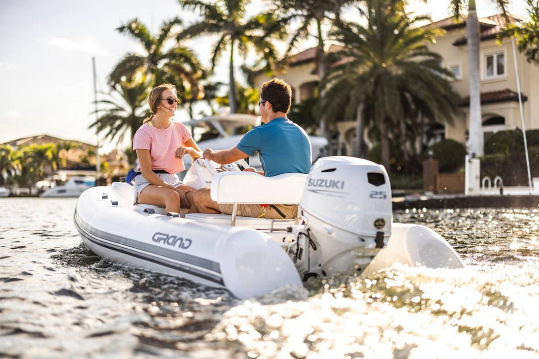 Suzuki 25 HP White Remote in Use on Dinghy Back View